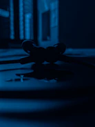 Close-up of a stylish open box wireless headphone set with a blue accent background.