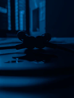 Artistic overhead view of in-ear monitors arranged on a matte black surface with subtle shadows