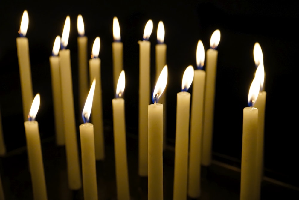 un groupe de bougies allumées dans une pièce sombre