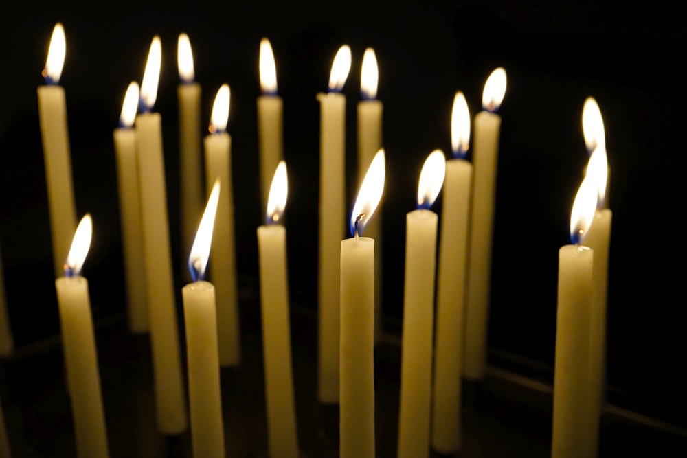 a group of lit candles in a dark room