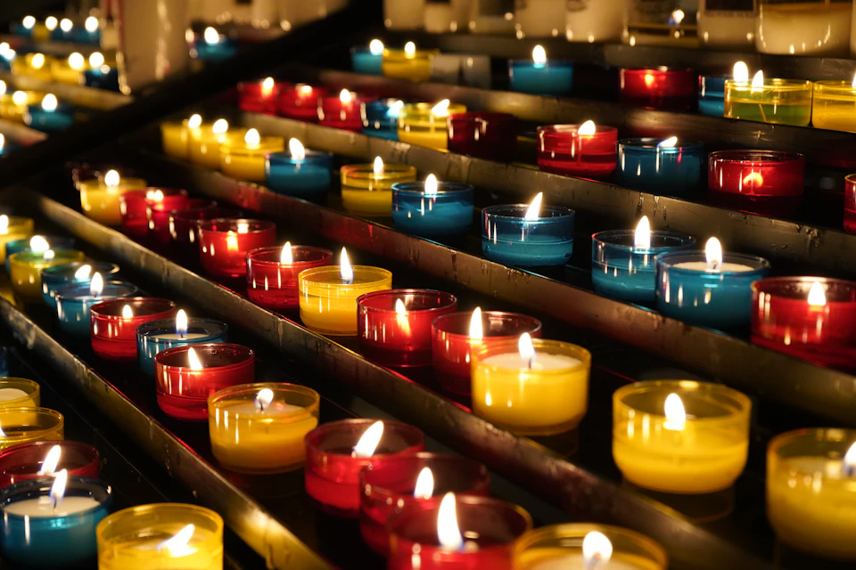 Display case filled with rows of uniquely colored and sized candles in various hues
