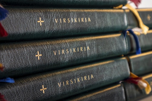 Stack of leather-bound memoir books with gold foil detailing on spines.