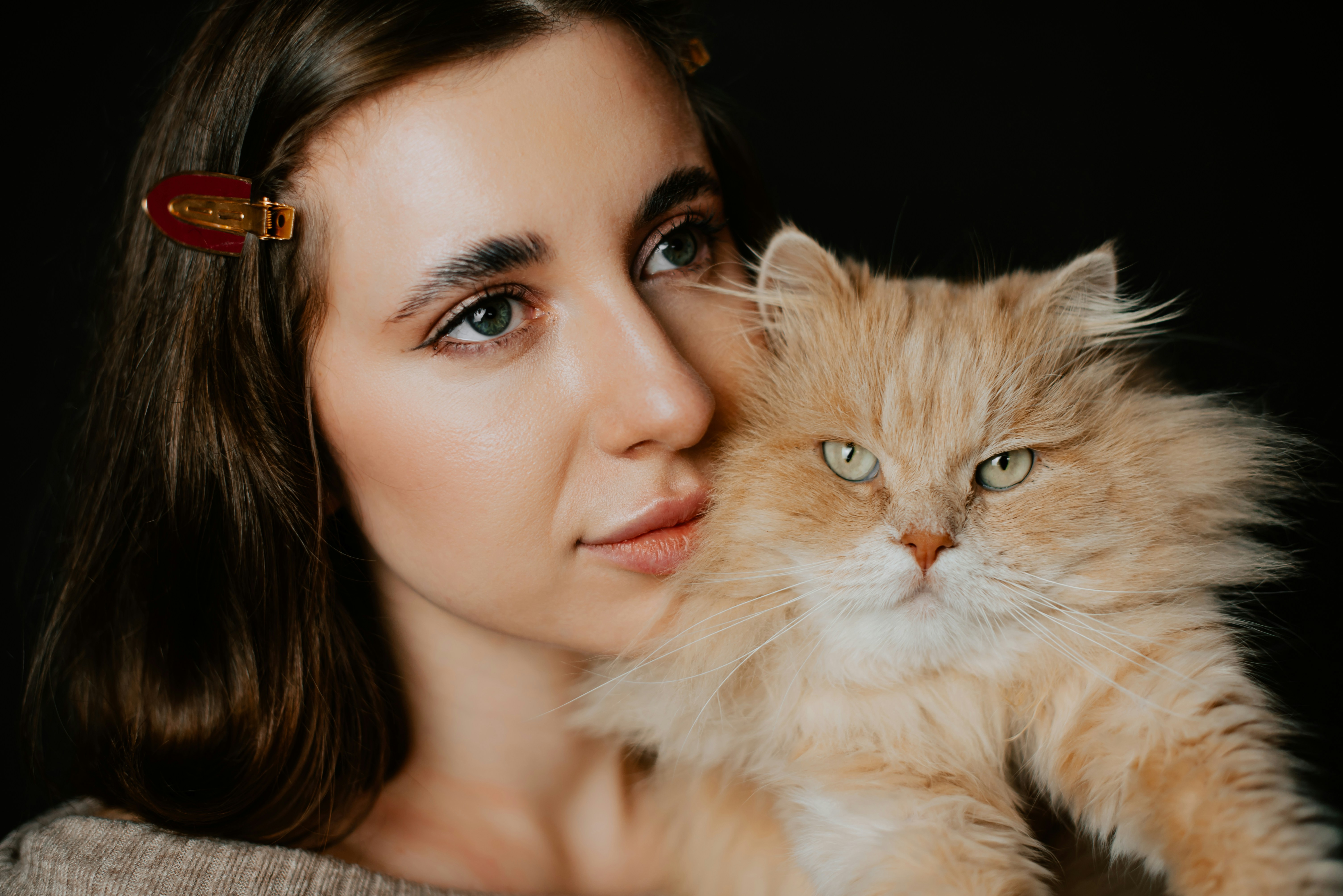 a woman holding a cat up to her face