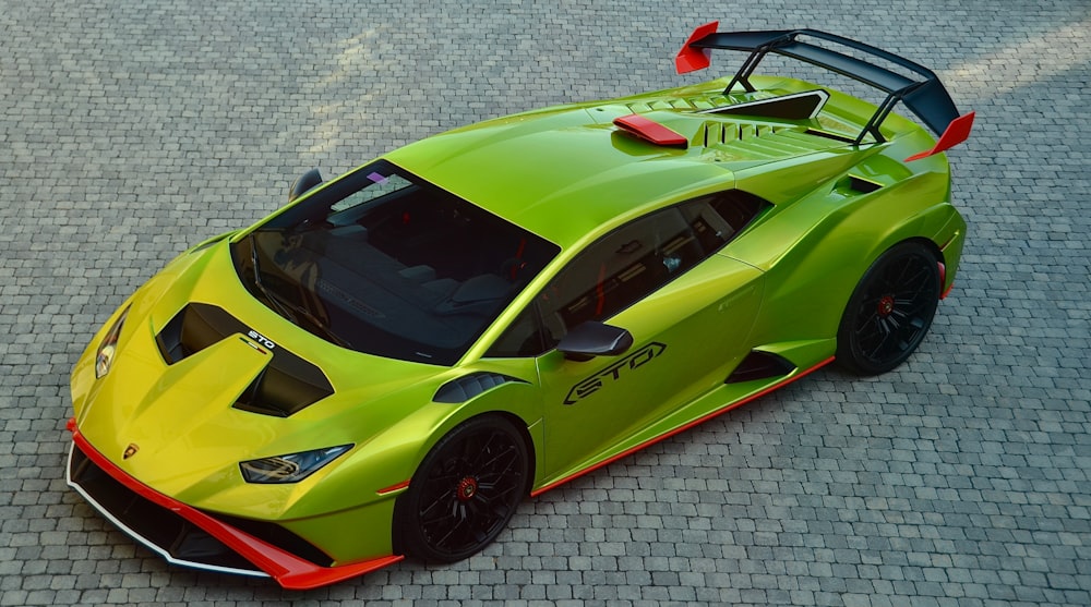 a green sports car parked on a brick road