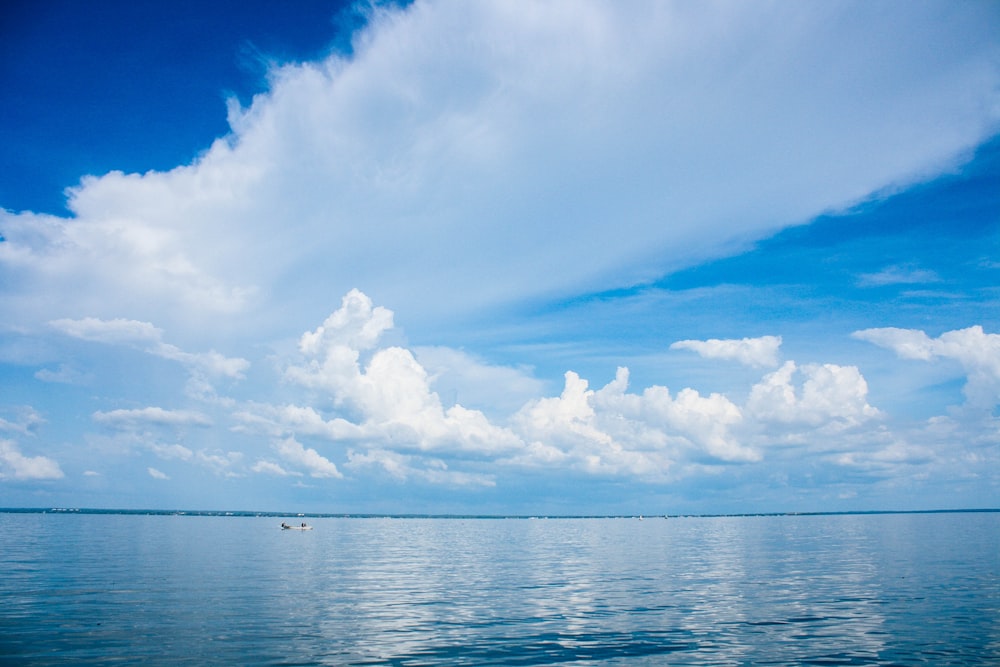 a large body of water under a cloudy blue sky