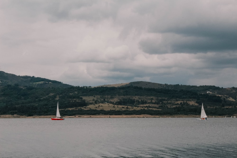 a couple of boats floating on top of a lake