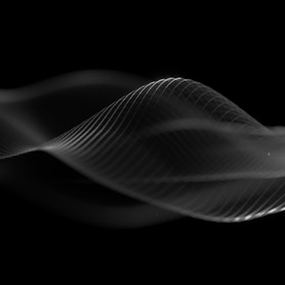 A slow-motion capture of silk flowing in dark ambient light creating movement.