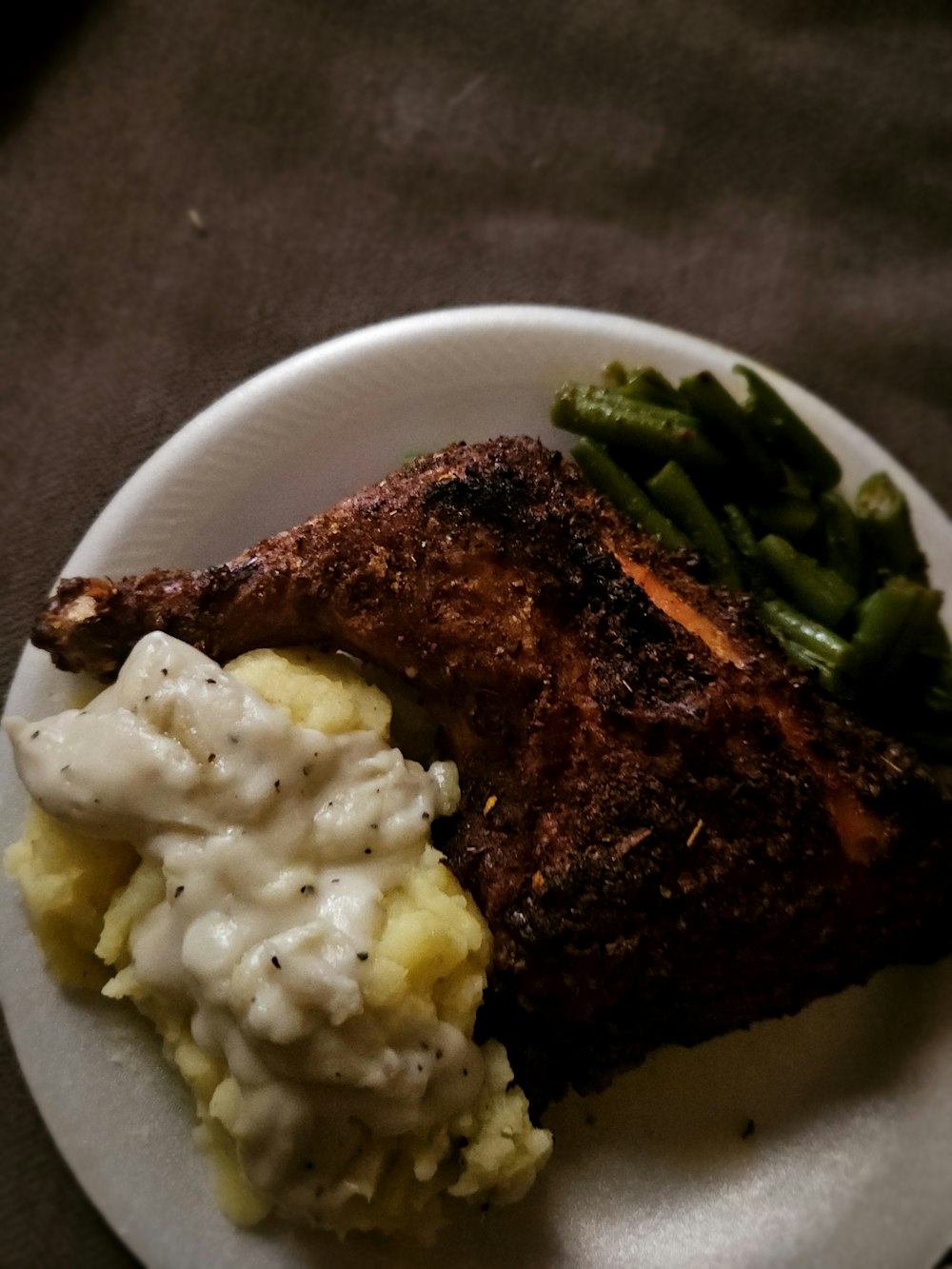 a white plate topped with meat and mashed potatoes