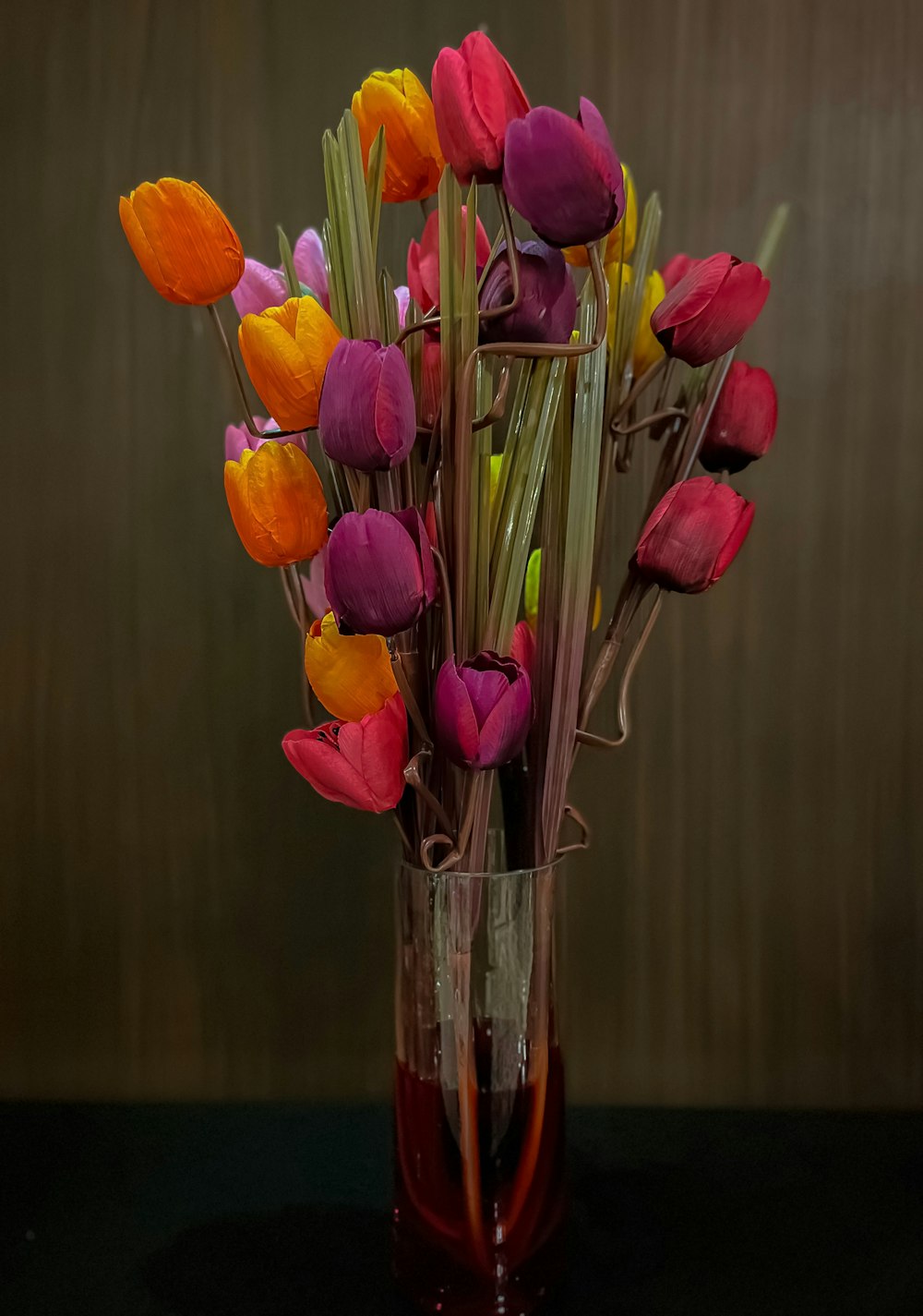 a vase filled with colorful flowers on top of a table