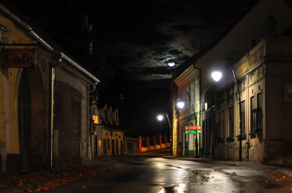 an empty street at night with a full moon in the sky