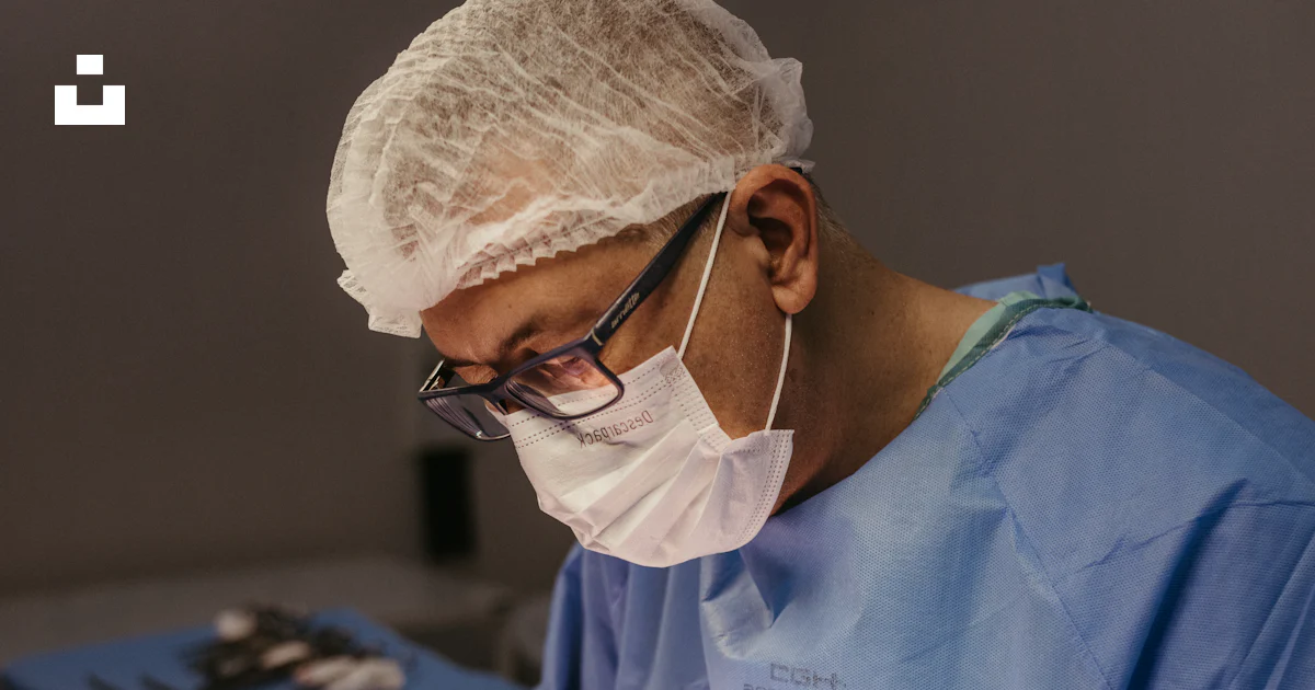 A surgeon performing surgery on a patient in an operating room photo ...