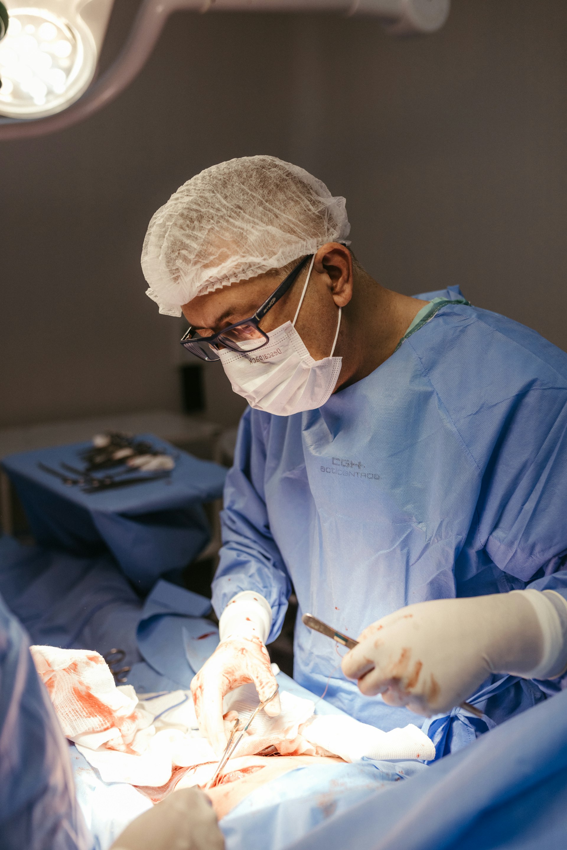 Surgical team performing a procedure in a modern operating room with monitors and imaging in view