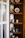 A cozy living room corner featuring elegant ceramic decorative figures on a wooden shelf.
