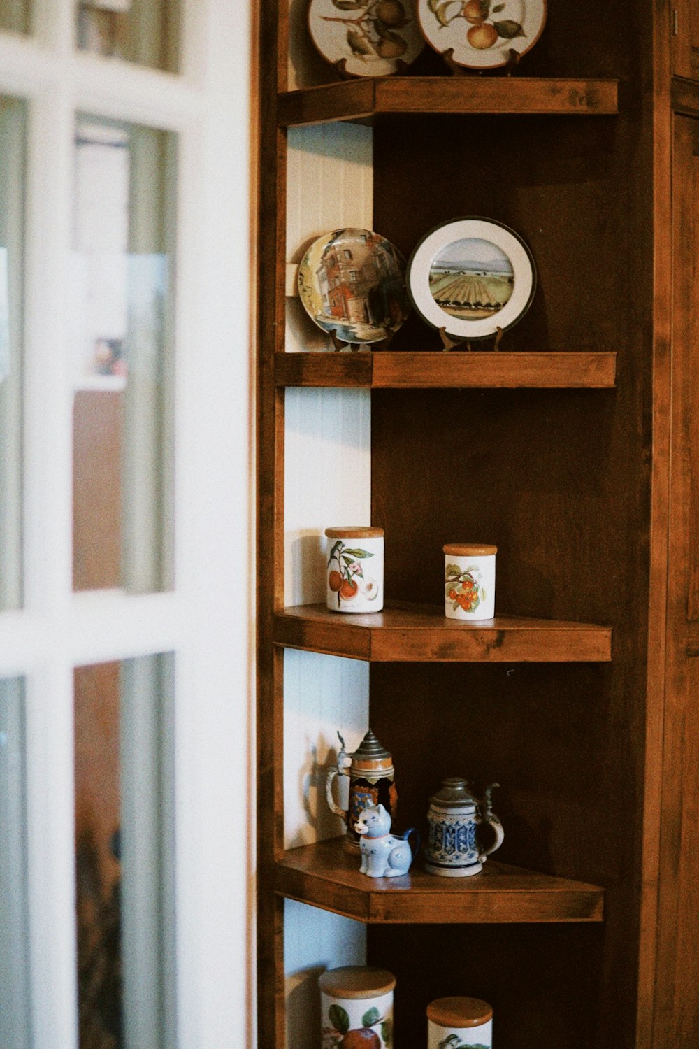 a wooden shelf with plates and cups on it