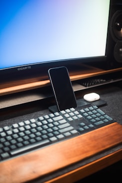 a cell phone sitting on top of a computer keyboard