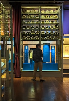 A collection of ancient scrolls and manuscripts displayed on a wooden table.