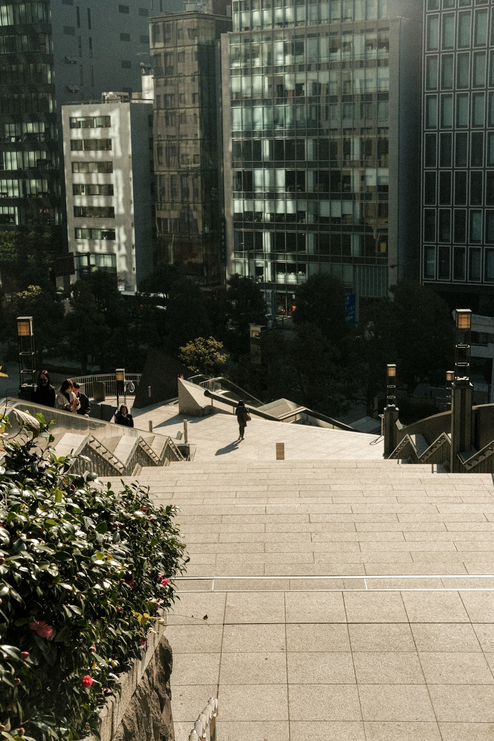 Un hombre montando una patineta por una acera junto a edificios altos