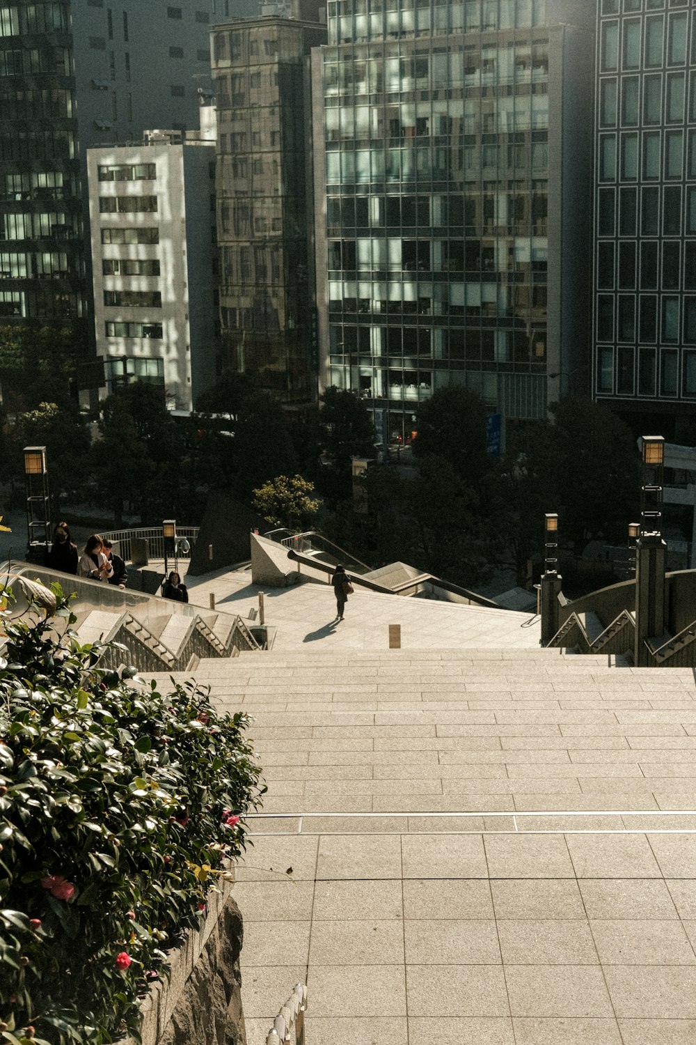 a man riding a skateboard down a sidewalk next to tall buildings