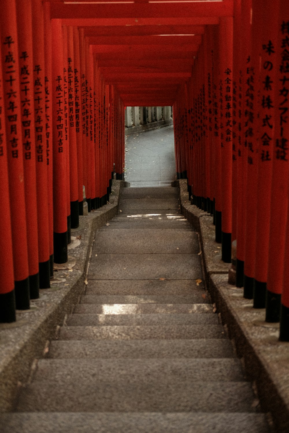 a walkway lined with red columns and writing on them