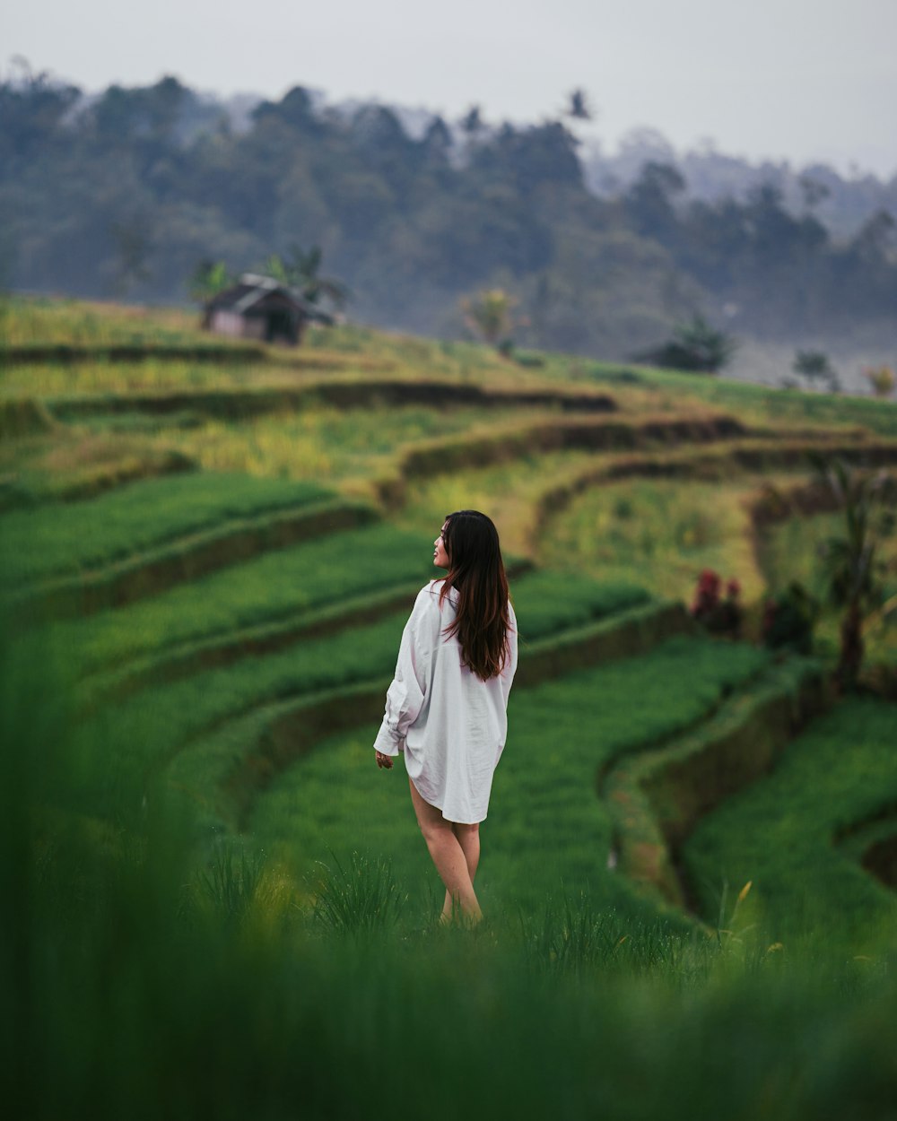 a woman standing in a field of green grass