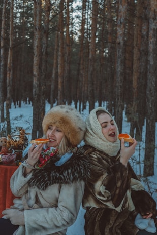 Two neighbors sharing a warm meal outside, smiling and connecting over food.