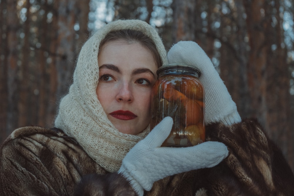 a woman in a fur coat holding a jar