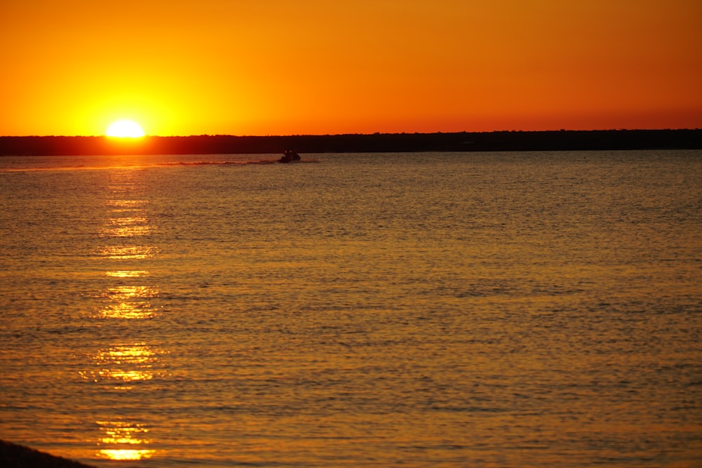 the sun is setting over a body of water