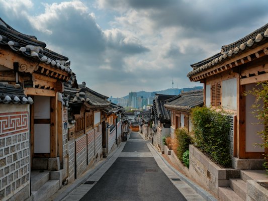A street lined with wooden buildings under a cloudy sky — Seoul, South Korea