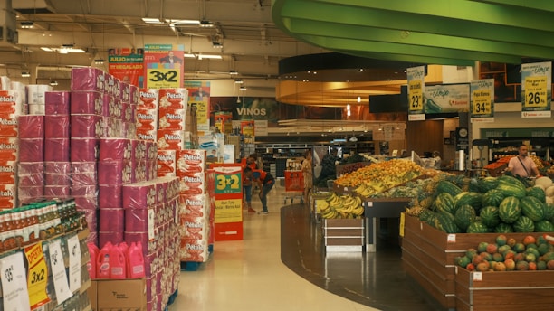A vibrant supermarket aisle with colorful promotional signs and happy shoppers.