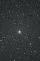 A night sky filled with countless stars. In the center, there is a brighter celestial object, possibly a galaxy or nebula, standing out against the dark backdrop. The vast, deep space evokes a sense of wonder and mystery.