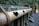 A series of bamboo sections are aligned horizontally, featuring heart-shaped cutouts with a green background. The bamboo is tied together with rope and set against a moss-covered stone wall, creating a natural and rustic scene.