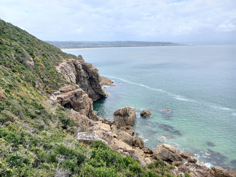 a body of water surrounded by a lush green hillside