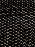 Close-up of hands inspecting fabric samples under bright light.