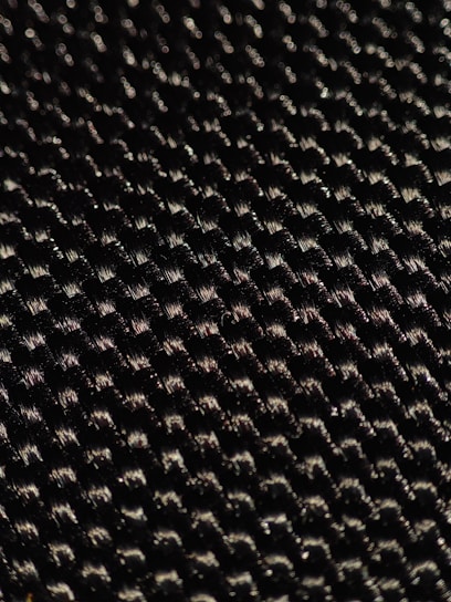 Close-up of premium textile fibers with a subtle metallic sheen under soft lighting.