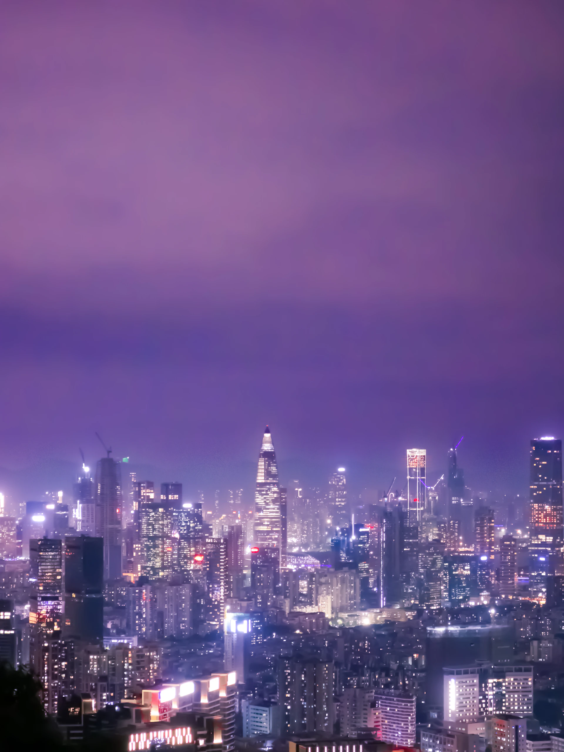 a view of a city at night from the top of a hill
