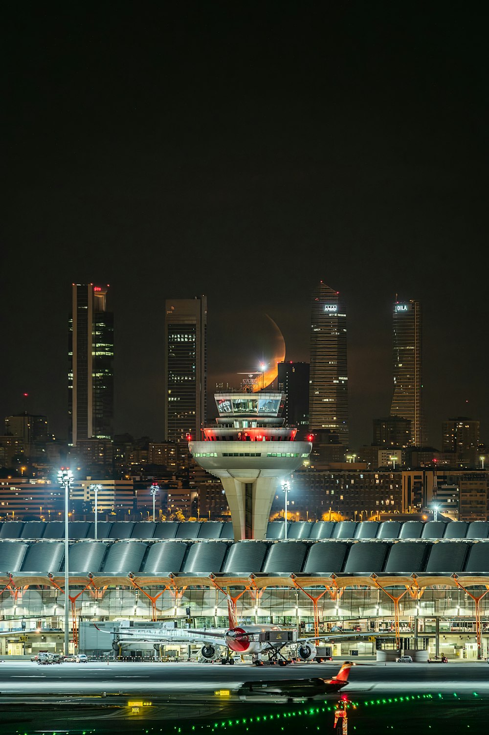 an airport at night with a view of the city