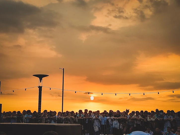 A striking photo of community members gathered in Agra, united in purpose under a vibrant orange sunset.