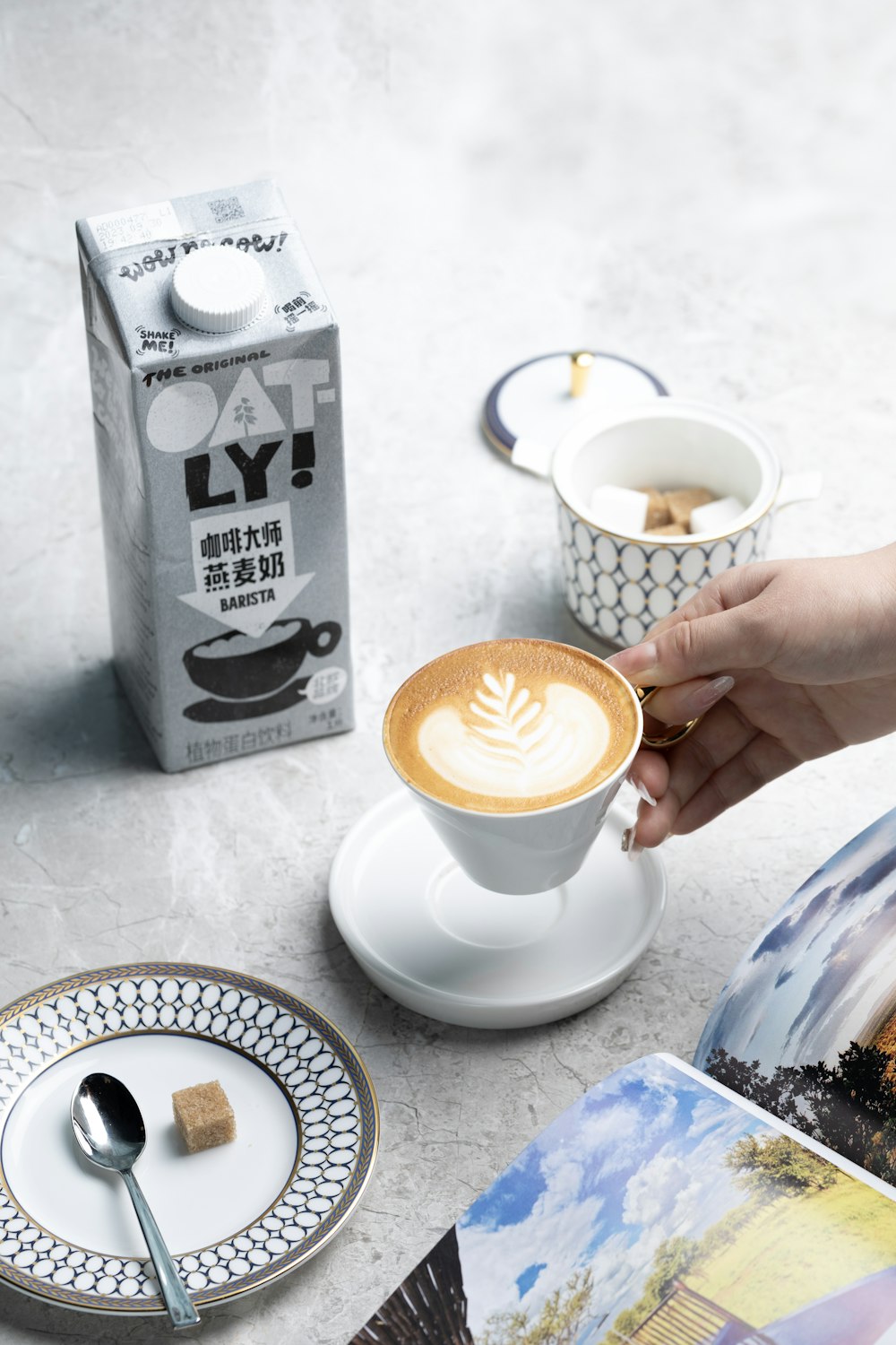 a person holding a cup of coffee on top of a table