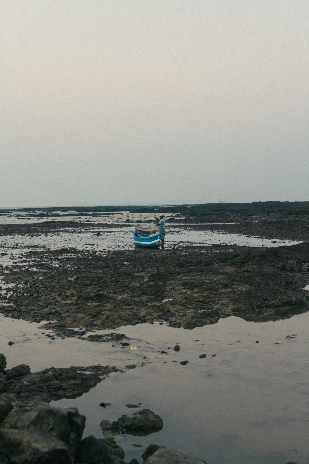 a boat sitting on top of a rocky beach