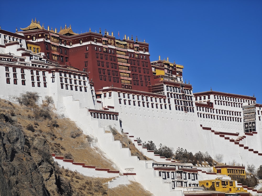 un gran edificio blanco y rojo en la cima de una colina