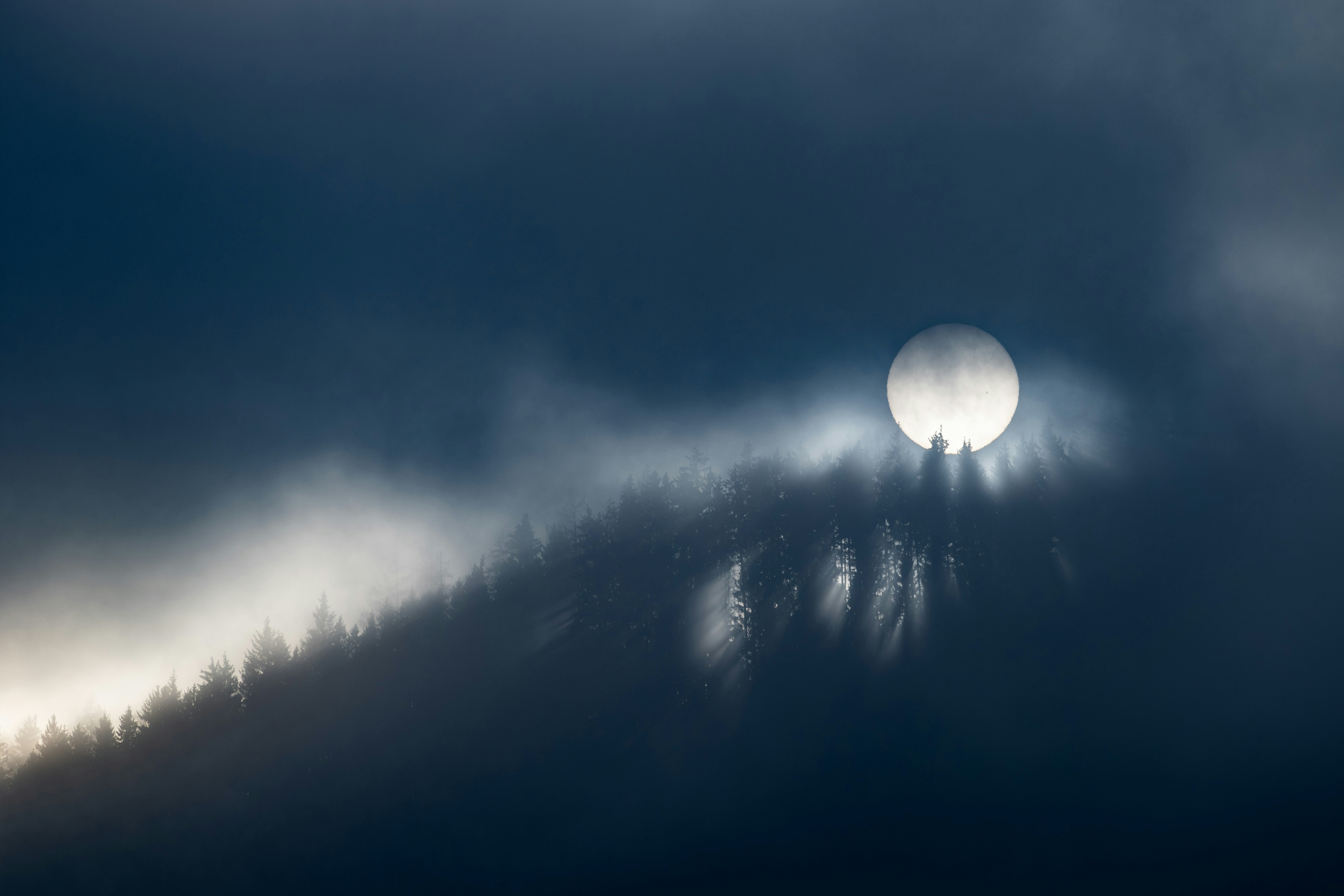 Die Sonne scheint durch die dunklen Wolken