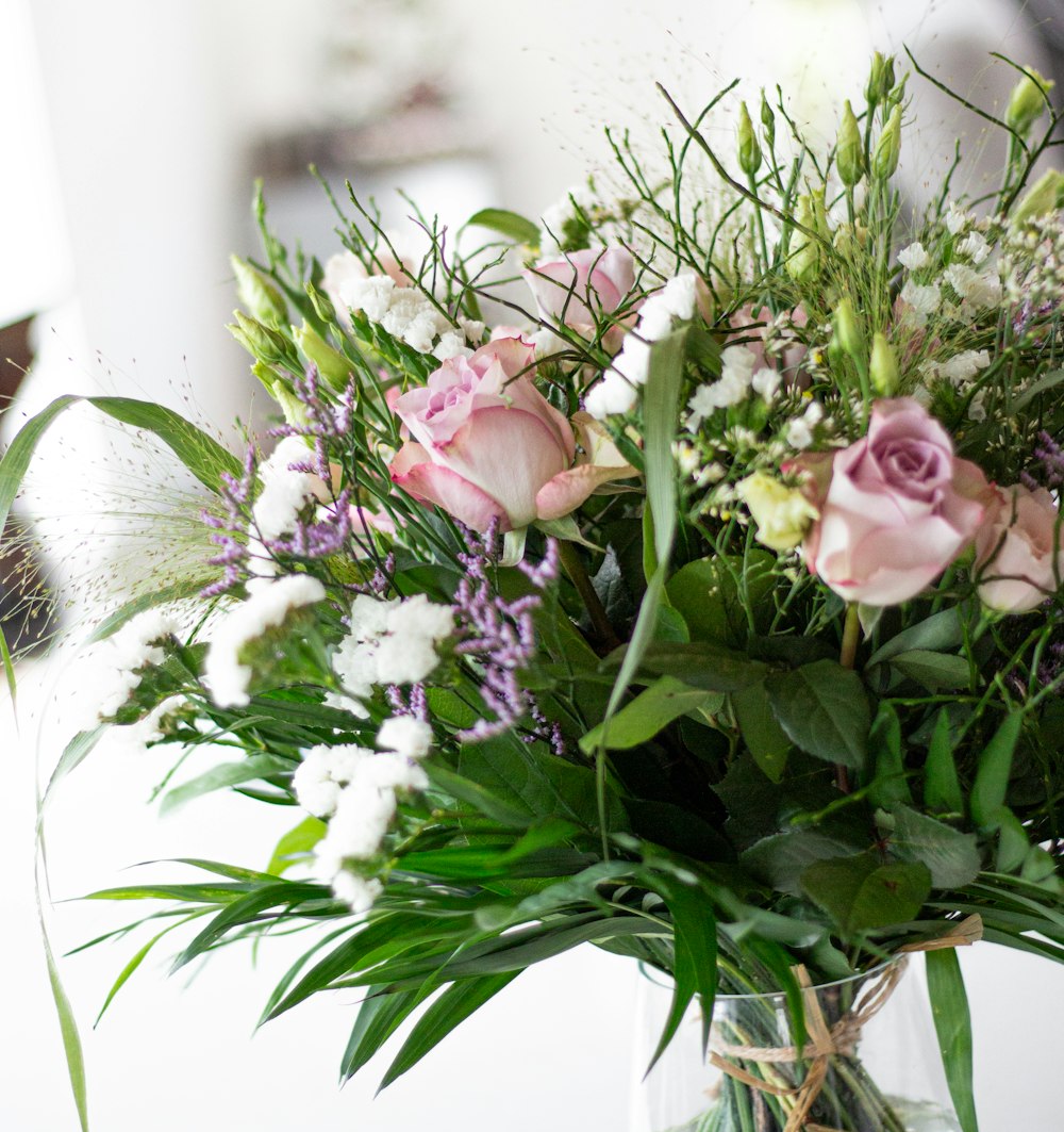 a vase filled with lots of flowers on top of a table