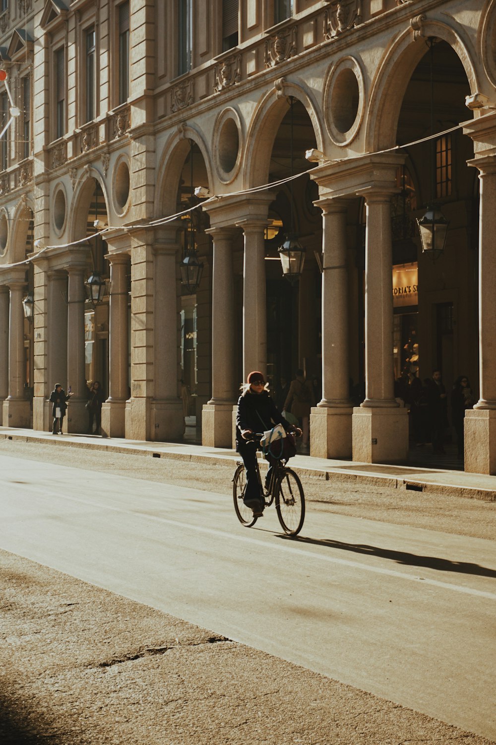 Un hombre andando en bicicleta por una calle junto a edificios altos