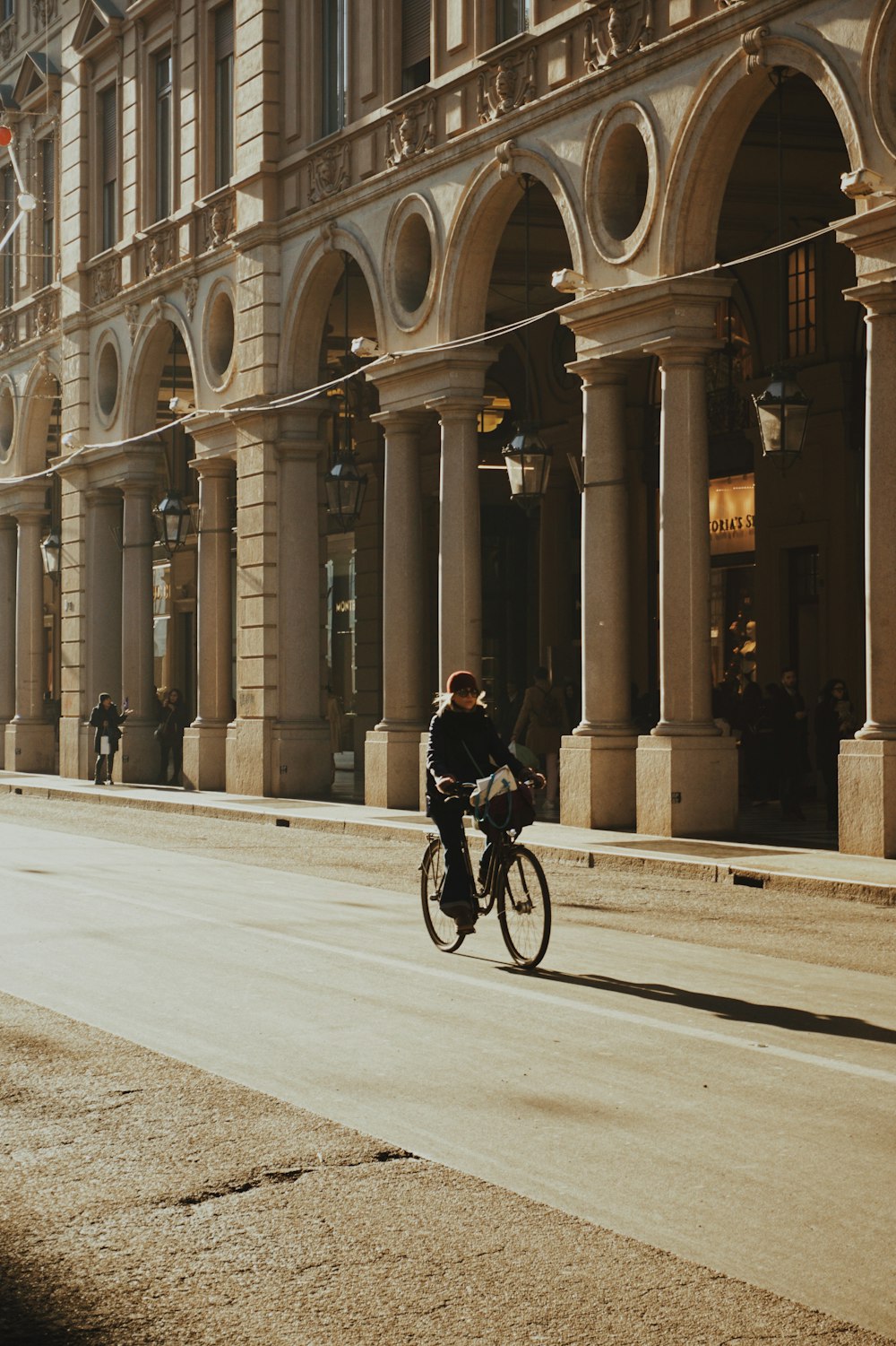 a man riding a bike down a street next to tall buildings