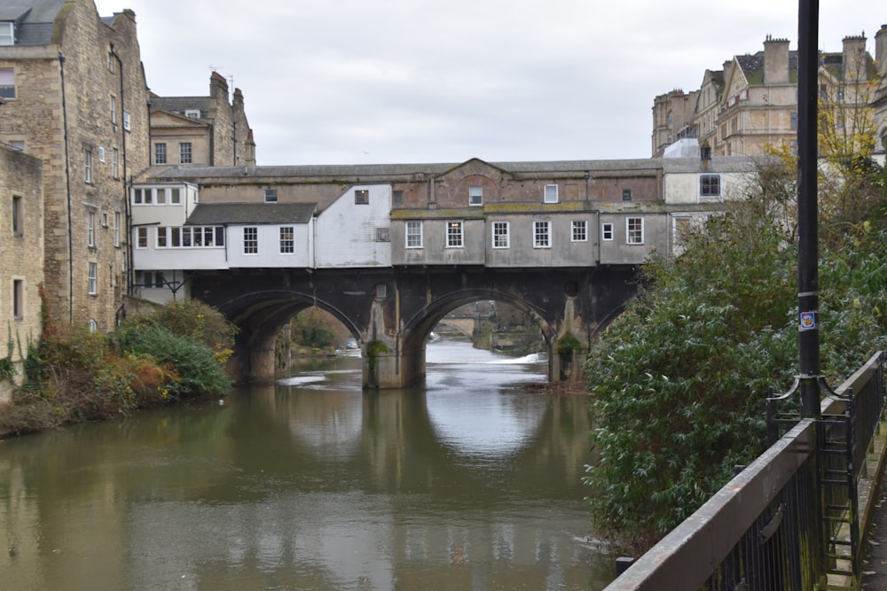 a river running under a bridge next to tall buildings