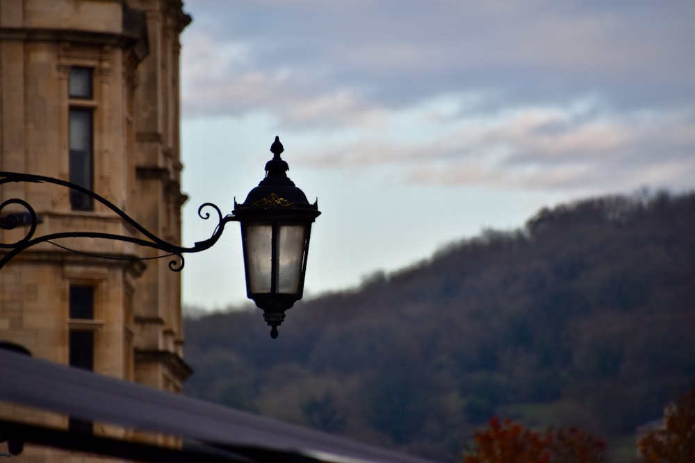 uma luz de rua pendurada na lateral de um edifício