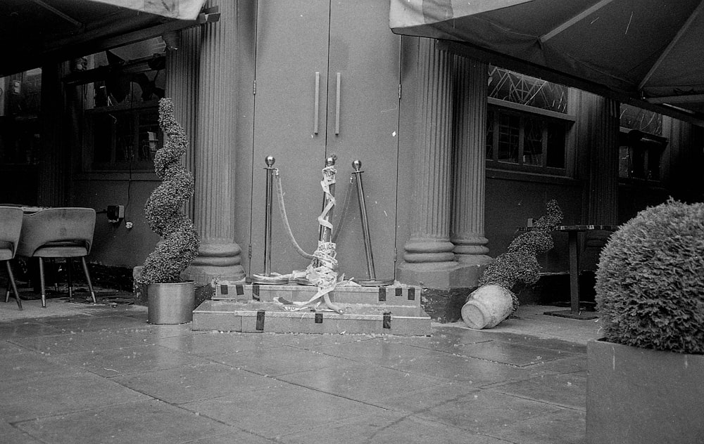 a black and white photo of a fountain in front of a building