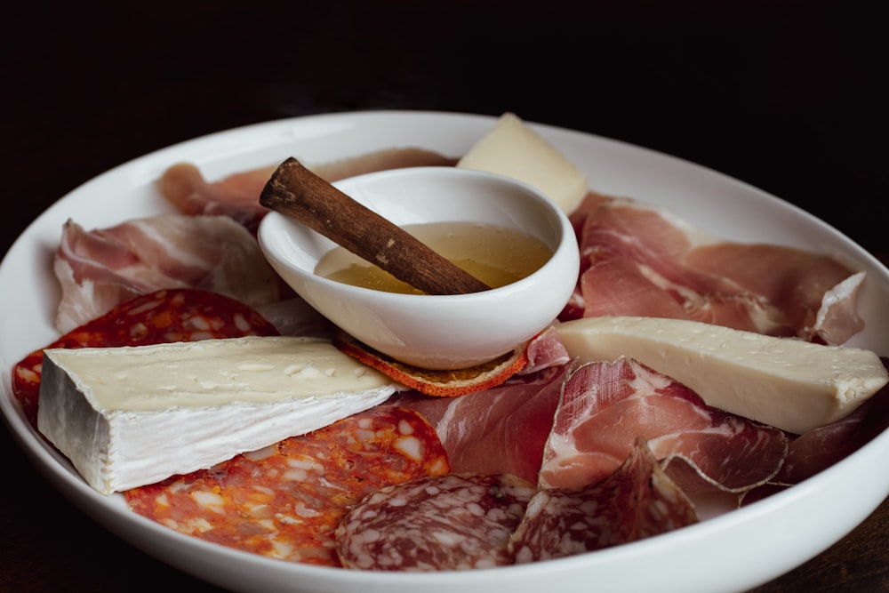 a white bowl filled with meat and cheese