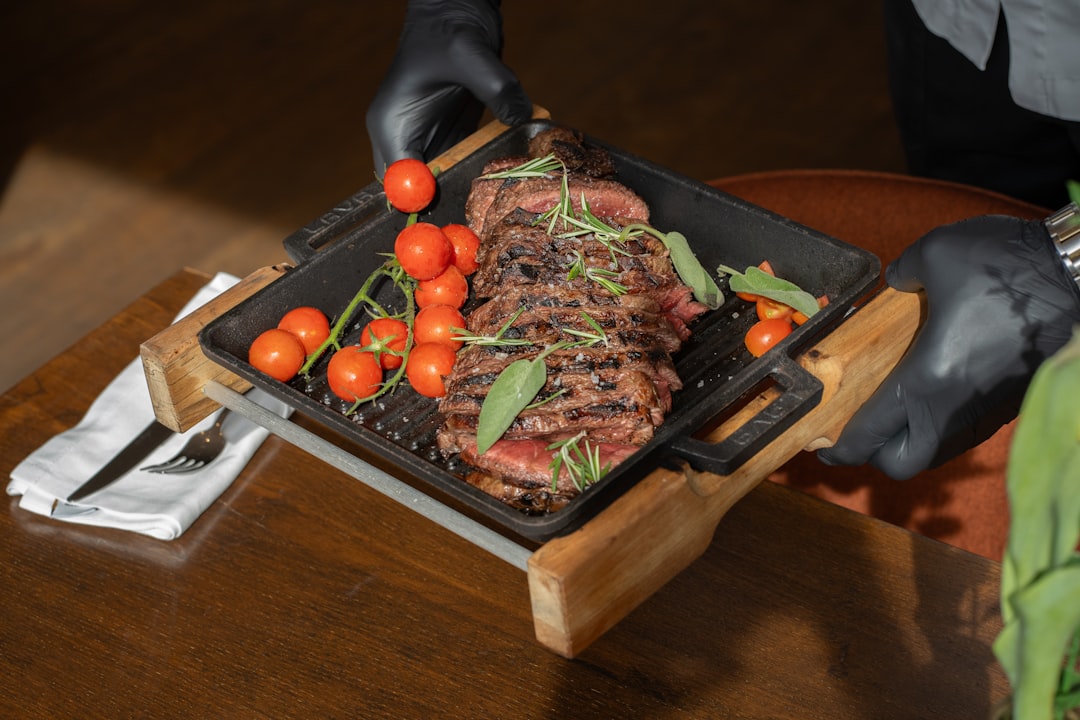 a person in black gloves holding a tray of food,