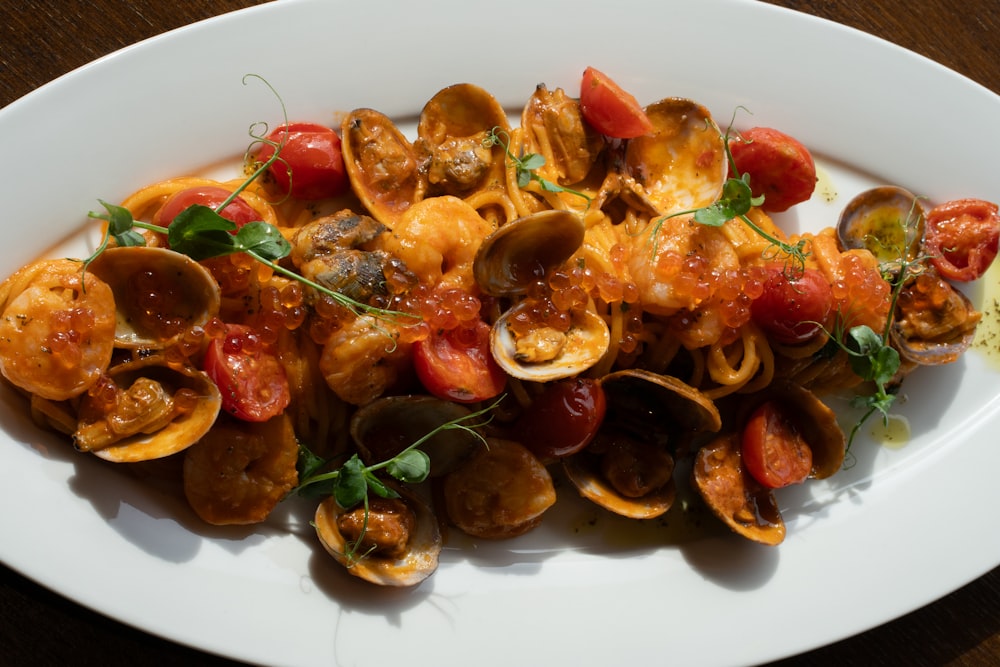 a white plate topped with clams and tomatoes